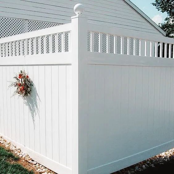 White vinyl fence with a decorative accent, surrounding a yard.