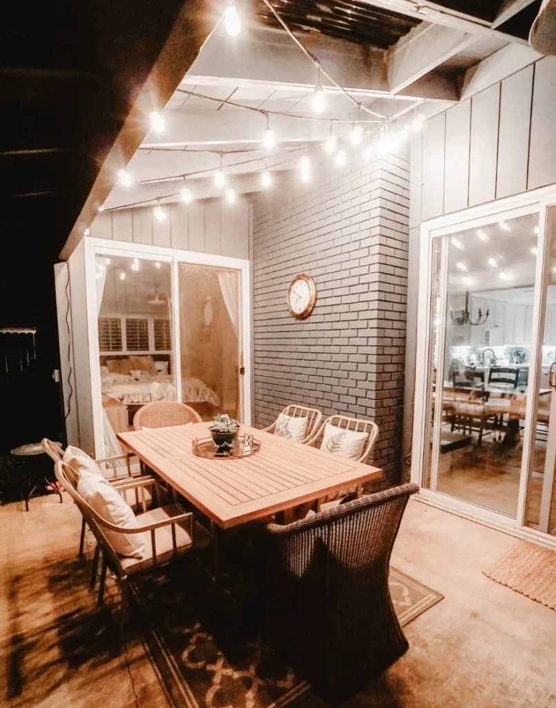 Cozy outdoor dining space with string lights and decor.