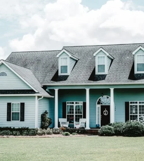 Beautiful suburban home with a large front yard, featuring classic architecture and a welcoming porch.