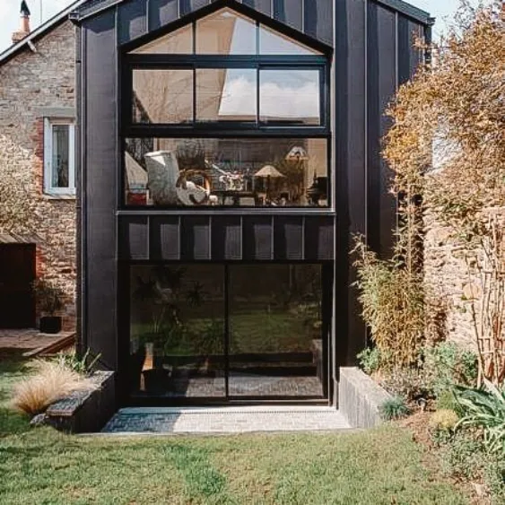 Modern home extension with large glass windows and a sleek black exterior.