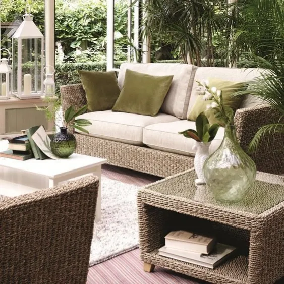 Cozy and elegant indoor seating area with wicker furniture and green accents.