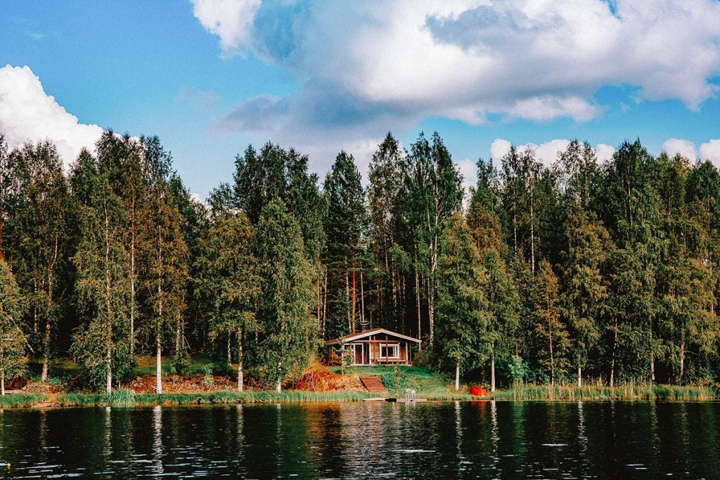 chalet ou cabin en forêt devant un lac au canada