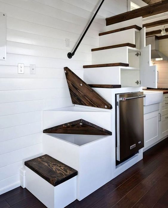 Rangement sous forme de tiroir sous les escaliers d'une mini-maison sur pieux vissés.