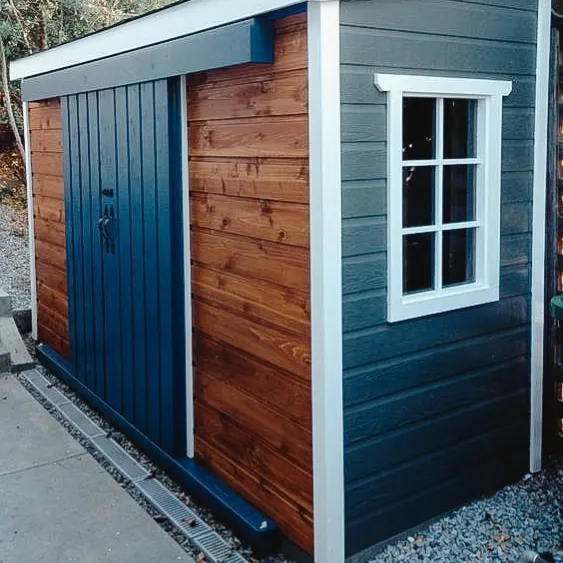 Compact and stylish shed with wooden and blue exterior, featuring a small window.