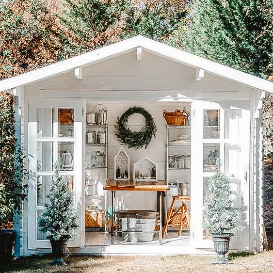 Charming white shed with organized interior storage and decorative touches.