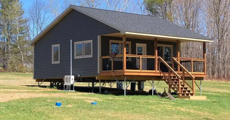 Blue home with veranda on screw pile by Postech North Central BC