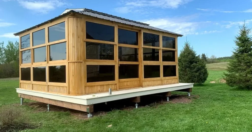 Wooden sunroom elevated on screw piles in a green landscape