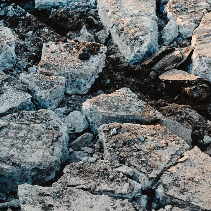 Gros plan sur des morceaux de béton brisés lors d'une excavation.